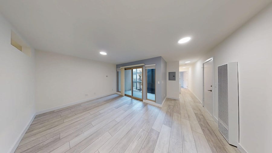A spacious room with wooden flooring and a white ceiling.